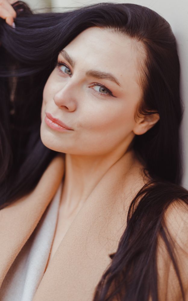 Woman with long black hair posing thoughtfully.