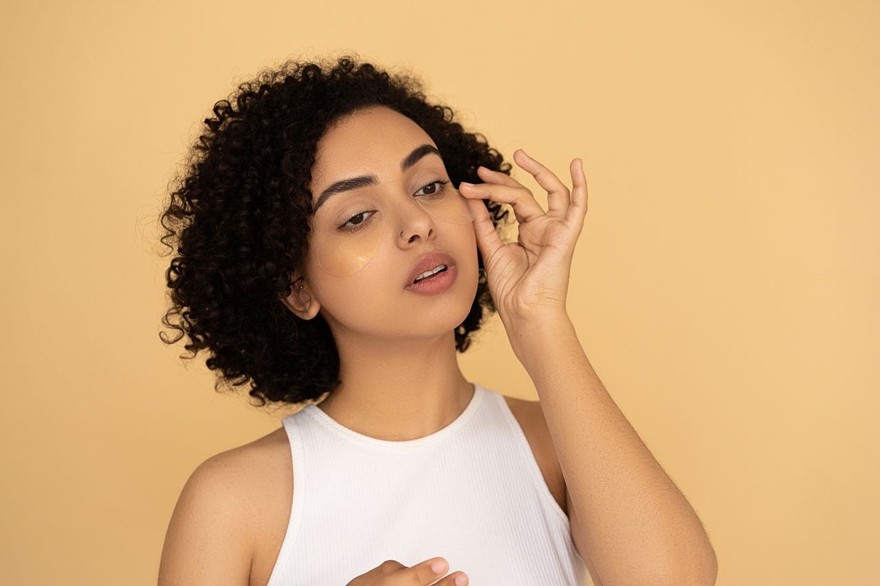 Woman applying skincare product on her face.